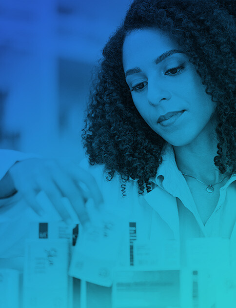 Female pharmacist looking at prescription drugs.